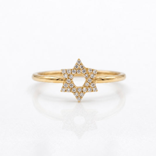 A gold ring featuring a six-pointed star pavé-set with small clear diamonds, shown on a clean white reflective surface.
