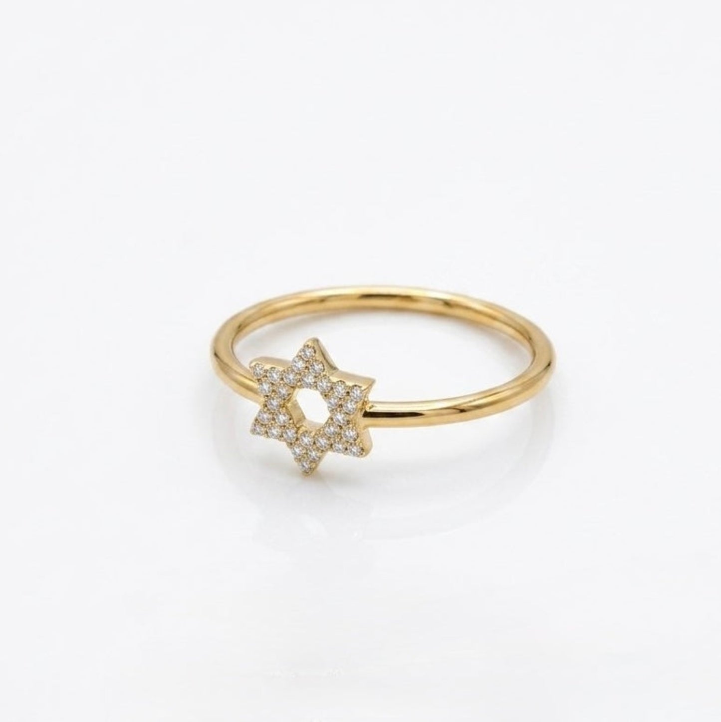 A delicate gold ring featuring a pavé-set Star of David charm, photographed on a clean white background.