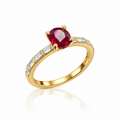 A yellow gold ring featuring a round-cut red ruby center stone, accented by a row of clear baguette-cut diamonds  along the band, shown on a white background with a soft reflection.