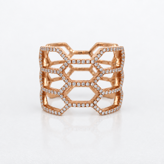 A rose gold geometric ring with a honeycomb lattice design, embellished with small pavé-set diamonds, shown on a clean white background.