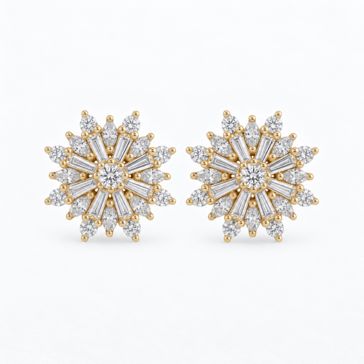 A pair of gold snowflake stud earrings set with clear baguette and round-cut diamonds, displayed on a clean white background.