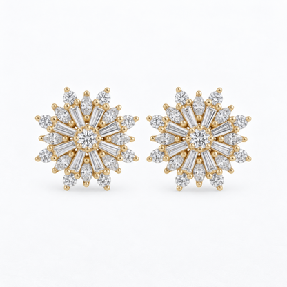 A pair of gold snowflake stud earrings set with clear baguette and round-cut diamonds, displayed on a clean white background.