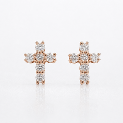 A pair of rose gold cross stud earrings set with clear round-cut diamonds, displayed on a clean white background with a soft reflection.