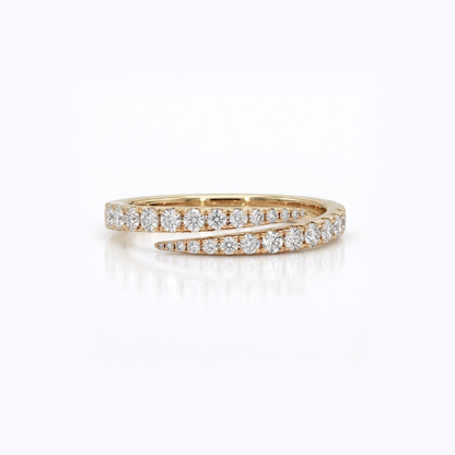 A yellow gold ring with pavé-set round diamonds, featuring a split design with one straight row and one curved row, shown on a clean white background with a soft reflection.