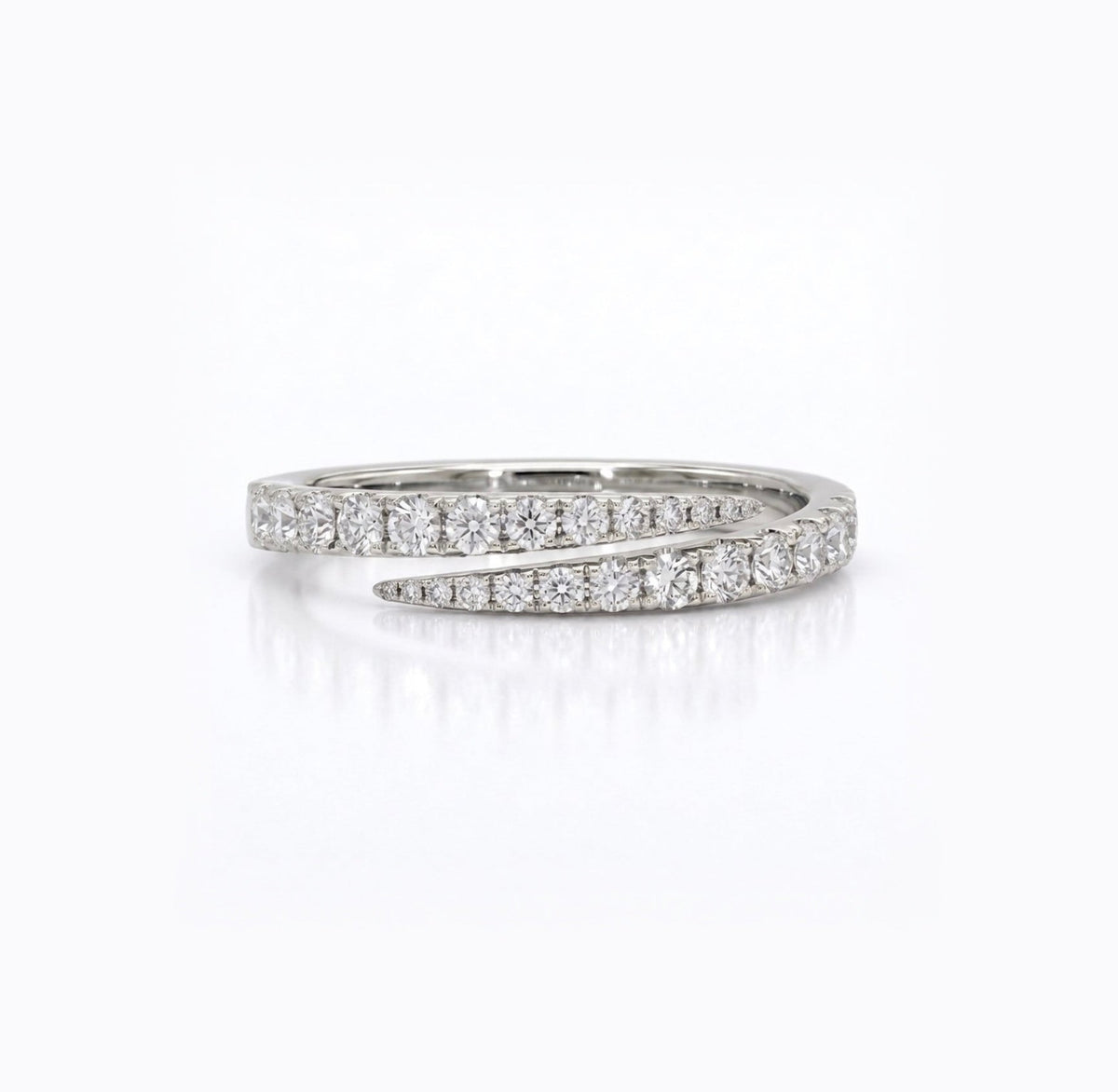 A silver wrap ring featuring pavé-set round diamonds on both bands, photographed on a clean white background with a soft reflection.