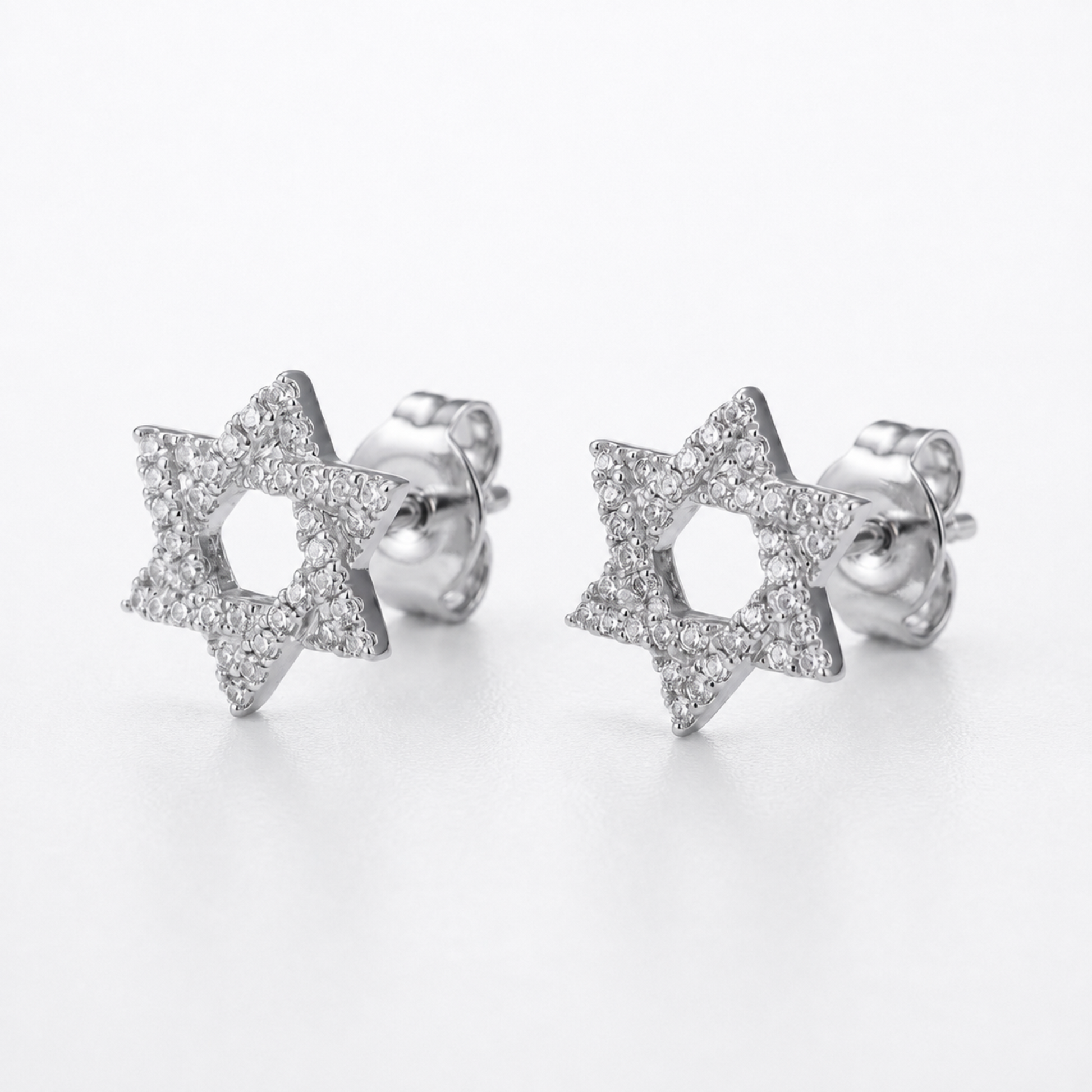 A pair of silver Star of David stud earrings paved with small diamonds, shown on a clean white background.