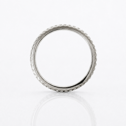 A silver band ring with a textured, beaded outer edge, photographed on a clean white reflective surface.