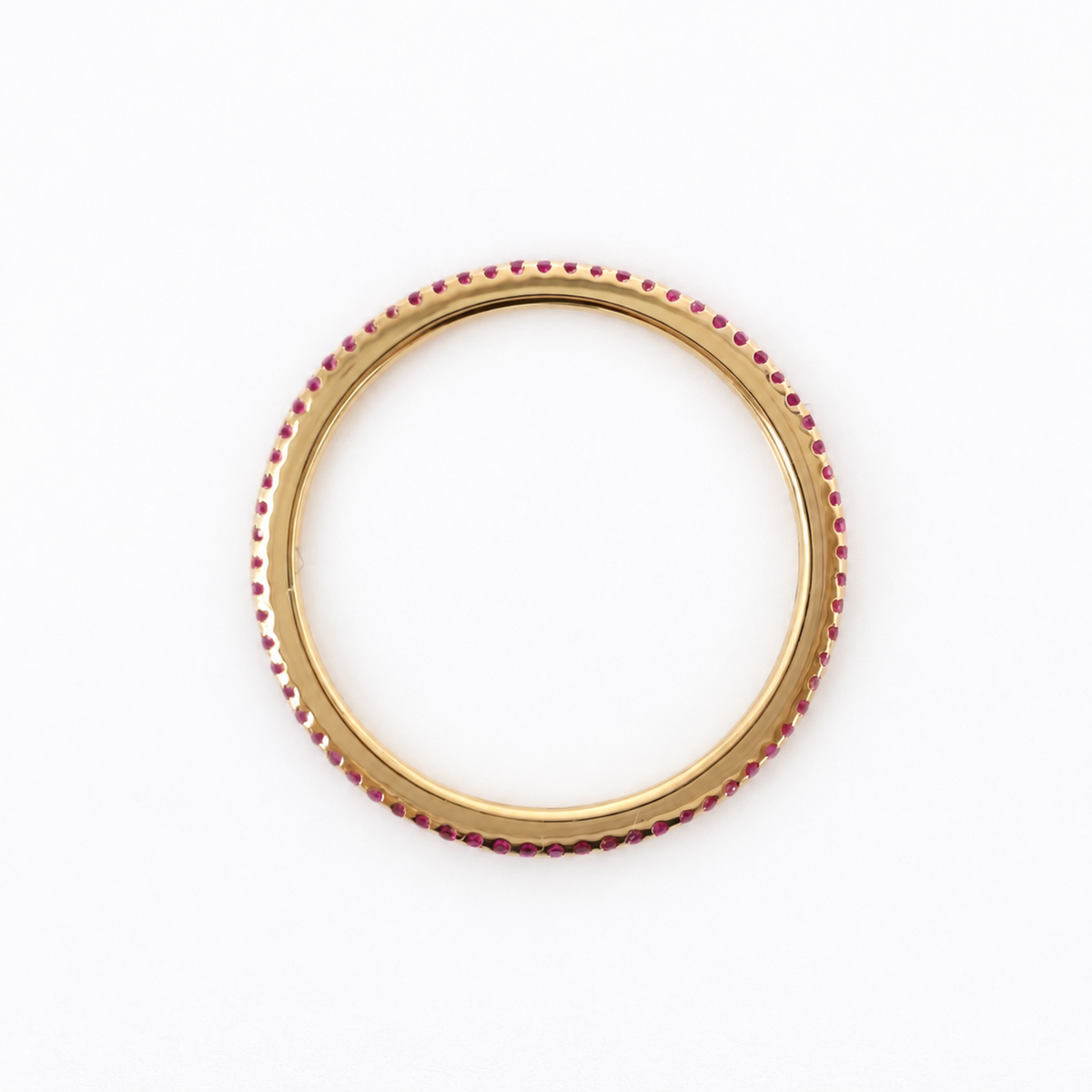 A gold ring adorned with small, evenly spaced red rubies along the outer edge, shown against a plain white background.